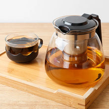 Detailed view of the glass kettle set with strainer and cups